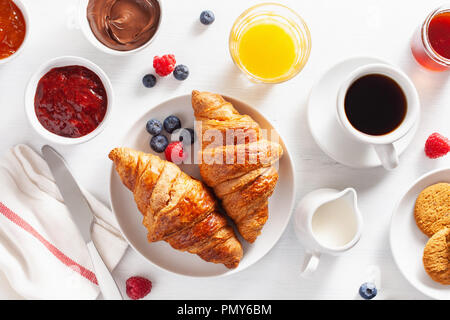 Petit déjeuner avec croissant, confiture, pâte à tartiner au chocolat et café. Vue d'en haut Banque D'Images