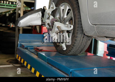 Pneu de voiture serrés avec réflecteur d'alignement pour l'outil de réglage de contrôle de l'alignement des roues dans le garage auto service de réparation Banque D'Images