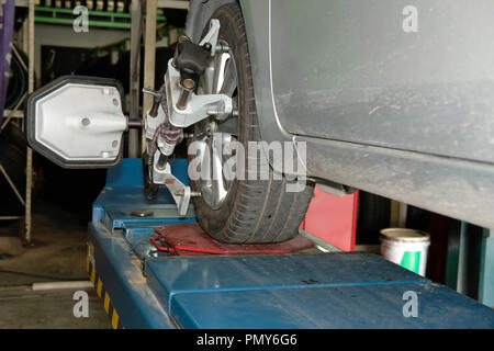 Pneu de voiture serrés avec réflecteur d'alignement pour l'outil de réglage de contrôle de l'alignement des roues dans le garage auto service de réparation Banque D'Images