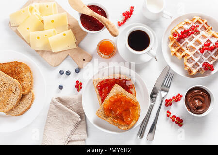 Petit déjeuner avec des gaufres, toasts, fruits, confiture, chocolat à tartiner et de café. Vue d'en haut Banque D'Images