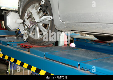 Pneu de voiture serrés avec réflecteur d'alignement pour l'outil de réglage de contrôle de l'alignement des roues dans le garage auto service de réparation Banque D'Images