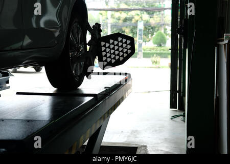 Pneu de voiture serrés avec réflecteur d'alignement pour l'outil de réglage de contrôle de l'alignement des roues dans le garage auto service de réparation Banque D'Images