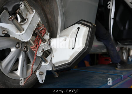 Pneu de voiture serrés avec réflecteur d'alignement pour l'outil de réglage de contrôle de l'alignement des roues dans le garage auto service de réparation Banque D'Images