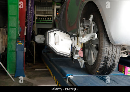 Pneu de voiture serrés avec réflecteur d'alignement pour l'outil de réglage de contrôle de l'alignement des roues dans le garage auto service de réparation Banque D'Images