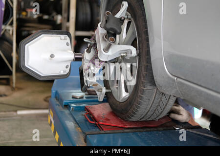 Pneu de voiture serrés avec réflecteur d'alignement pour l'outil de réglage de contrôle de l'alignement des roues dans le garage auto service de réparation Banque D'Images