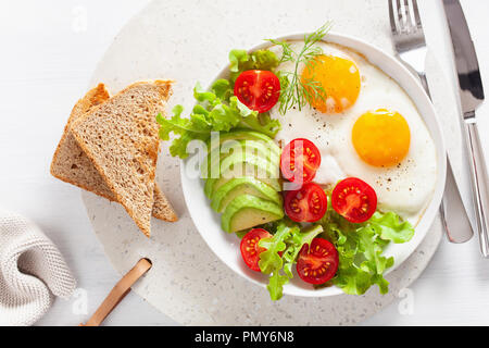 Petit-déjeuner sain télévision lay. d'œufs au plat, avocat, tomate, toasts Banque D'Images