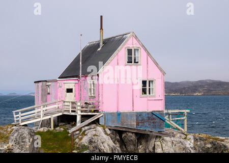 Les Inuits typiques maisons en bois peint en rose avec des filets de pêche à l'extérieur de séchage. Itilleq, Qeqqata, au Groenland. Sur une petite île à 2 km au nord du cercle arctique Banque D'Images