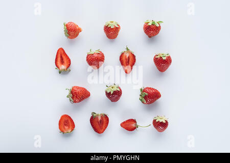 Vue de dessus de moitié et l'ensemble des fraises sur surface blanche Banque D'Images