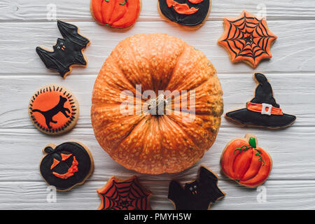 Vue de dessus de la citrouille halloween entouré par les cookies sur table en bois Banque D'Images