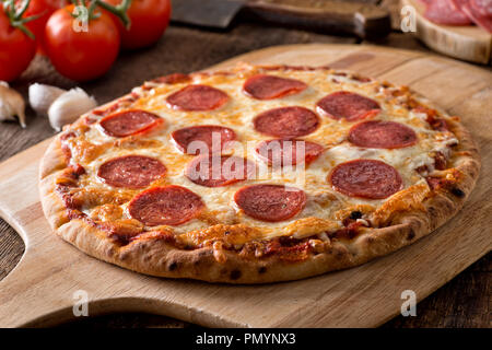 Une délicieuse pizza au pepperoni fraîches maison sur une pizza en traction. Banque D'Images