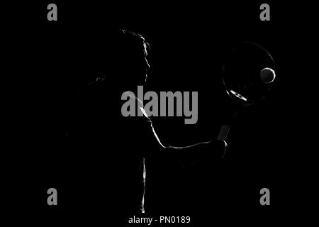 Tennis player silhouette sur fond noir. Banque D'Images