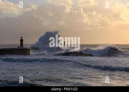 Embouchure de la rivière Douro, le port de Porto, avec de grosses vagues sur la jetée et de phares au coucher du soleil Banque D'Images