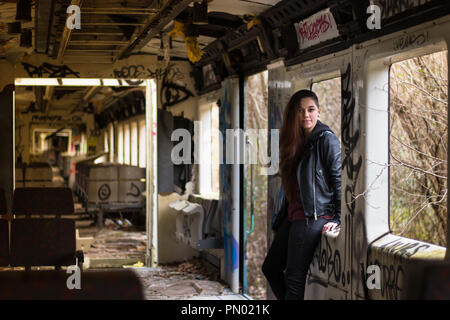 Portrait Jeune femme avec de longs cheveux rouges grounge posant dans un endroit plein de graffity Banque D'Images