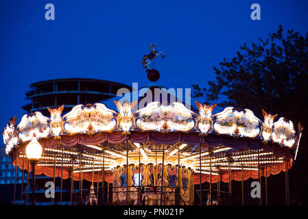 Carrousel pour enfants dans un parc d'attractions dans la soirée et nuit. Parc d'éclairage de nuit. Vintage en plein air dans le carrousel coloré la ville détail carrousel. Traitement photo Vintage Banque D'Images