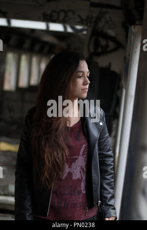 Portrait Jeune femme avec de longs cheveux rouges grounge posant dans une maison abandonnée pleine de graffity Banque D'Images