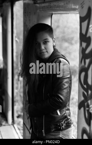 Portrait Jeune femme avec de longs cheveux rouges grounge posant dans une maison abandonnée pleine de graffity Banque D'Images