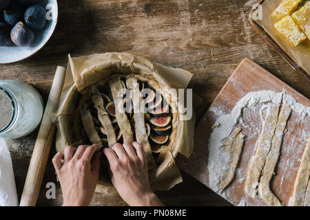 Cropped shot of woman preparing délicieux fig pie sur table en bois rustique Banque D'Images