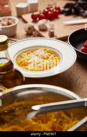 Gros plan de la plaque sur les spaghettis entouré d'ingrédients sur la table en bois Banque D'Images