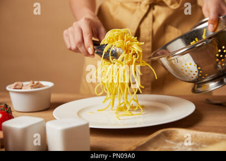 Cropped shot of woman putting spaghetti sur la plaque de passoire Banque D'Images