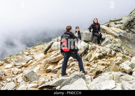 Les touristes sont photographiés dans les montagnes contre l'arrière-plan de roches. Banque D'Images