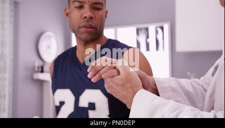 Joueur de basket-ball universitaire avec des blessures sportives d'être examiné par un médecin. Banque D'Images