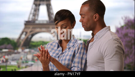 Ethnique joyeux couple nouvellement engagée, debout près de la Tour Eiffel à Paris, France Banque D'Images