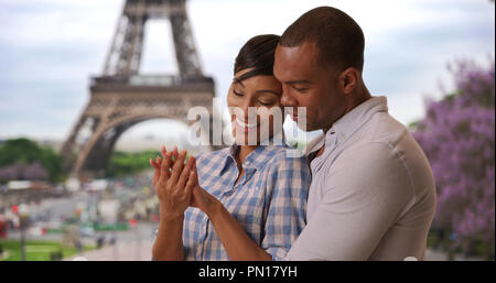 Ethnique joyeux couple nouvellement engagée, debout près de la Tour Eiffel à Paris, France Banque D'Images