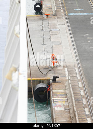 Docker ou manutentionnaire marche à côté d'un navire cargo vient d'arriver dans le port de Barcelone. Banque D'Images