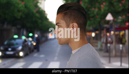 Profil de l'homme hispanique avec cool miner standing on city street Banque D'Images