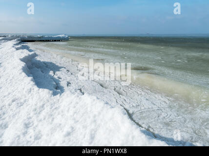 Boues de glace dans la mer d'huile, plate-forme dans la mer d'hiver à l'horizon Banque D'Images