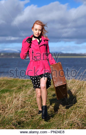 Smartly dressed woman at quayside avec vieille valise Banque D'Images