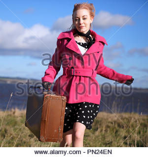 Smartly dressed woman at quayside avec vieille valise Banque D'Images