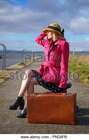 Smartly dressed woman at quayside avec vieille valise Banque D'Images