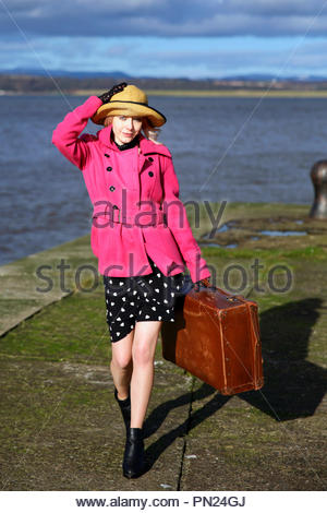 Smartly dressed woman at quayside avec vieille valise Banque D'Images