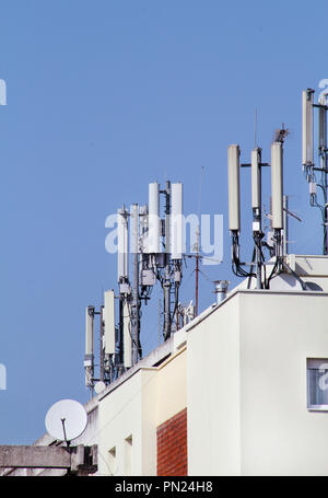 Les stations de base des télécommunications répéteurs réseau sur le toit de l'édifice. La communication cellulaire antenne sur le toit d'un bâtiment. Banque D'Images