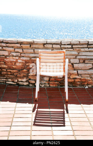 Chaise blanche sur un balcon. Littoral méditerranéen traditionnel et le temps de repos sur la terrasse et une vieille chaise blanc bleu de la mer. Chaise vide sont à remorquer Banque D'Images