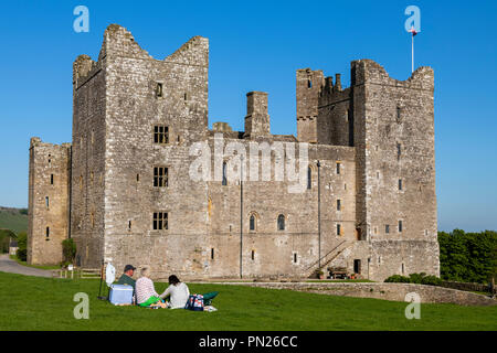 Les gens s'assoient et ont pique-nique sous le ciel bleu par château médiéval historique dans une belle campagne - Bolton Castle, Wensleydale, North Yorkshire, Angleterre Royaume-uni Banque D'Images