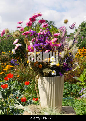 Bouquet de fleurs séchées dans un vase blanc Banque D'Images