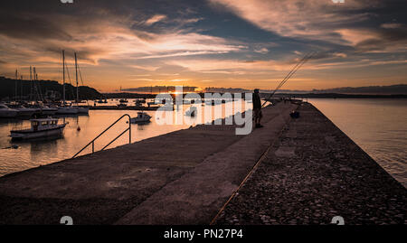 Pêcheur au coucher du soleil, le brise-lames à Brixham Banque D'Images