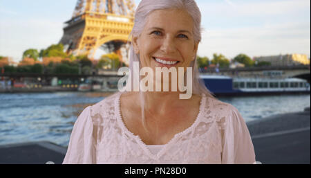 Portrait of cute occasionnels retraité senior woman in Paris laughing at camera Banque D'Images