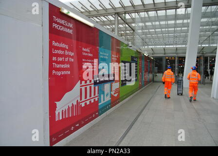 Deux accidents ferroviaires Réseau non identifiables en passant devant une affiche de publicité du programme Thameslink, London, England, UK Banque D'Images