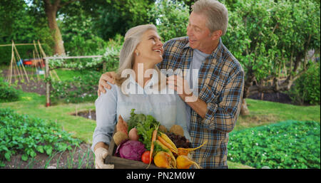 Young couple pose fièrement avec les produits de jardin personnels Banque D'Images