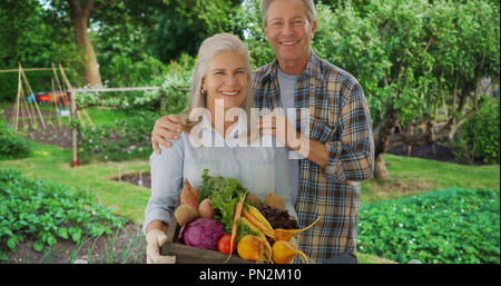 Young couple pose fièrement avec les produits de jardin personnels Banque D'Images