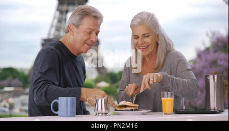 De plus, hommes et femmes blanc près de Eiffel Tower manger petit déjeuner délicieux feuilletée Banque D'Images