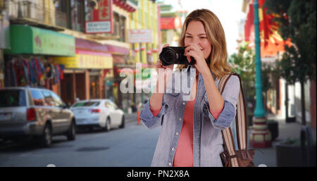 Cheerful woman visiter et prendre des photos dans Chinatown San Francisco Banque D'Images