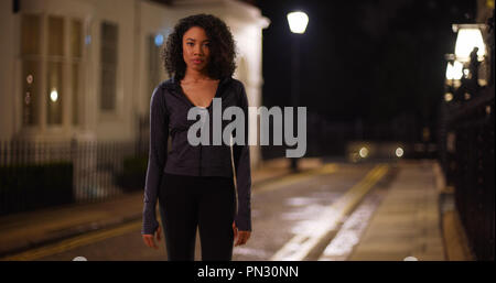 Jolie femme active wear dans la nuit en toute confiance looking at camera Banque D'Images