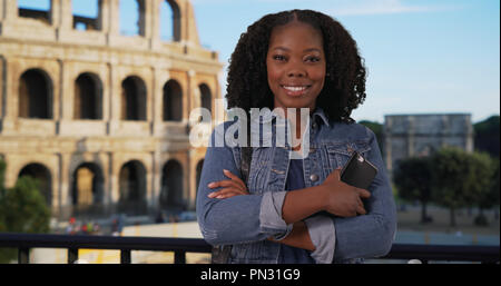 Portrait de femme noire occasionnels avec un sourire radieux colisée romain en arrière-plan Banque D'Images