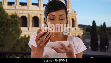Close up portrait of African American Woman in Rome Italie eating pizza Banque D'Images