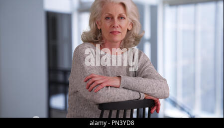 Serious mature woman sitting in modern office building looking at camera Banque D'Images