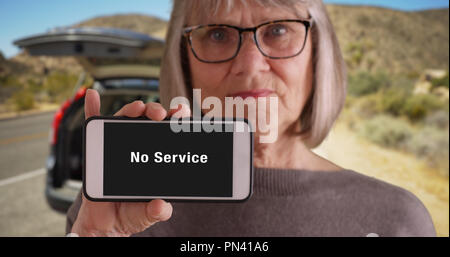 Sombre à la vieille femme tira sur le route du désert sans service sur le téléphone Banque D'Images